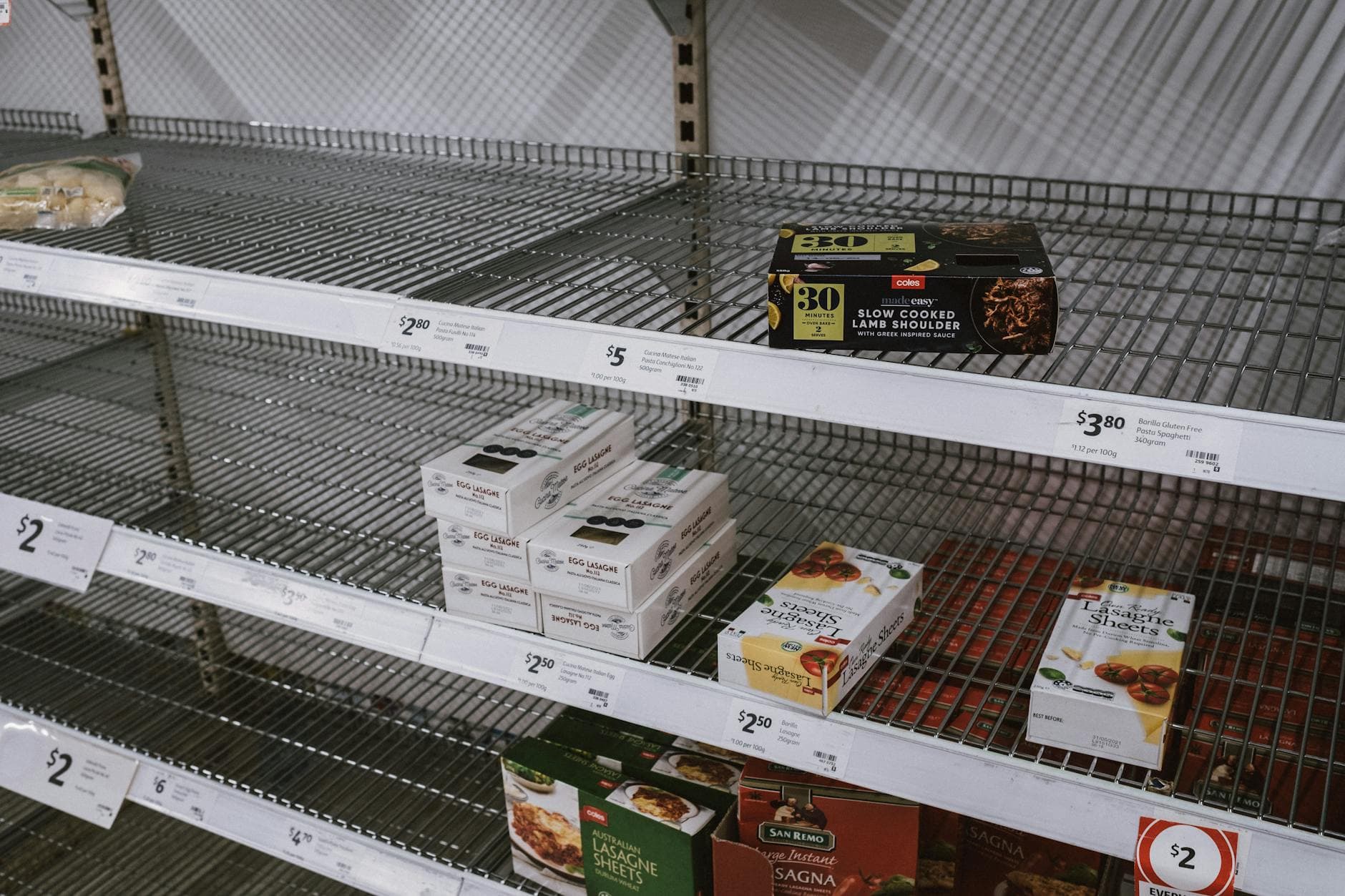Image of partially empty grocery shelves in Sydney highlighting food scarcity.