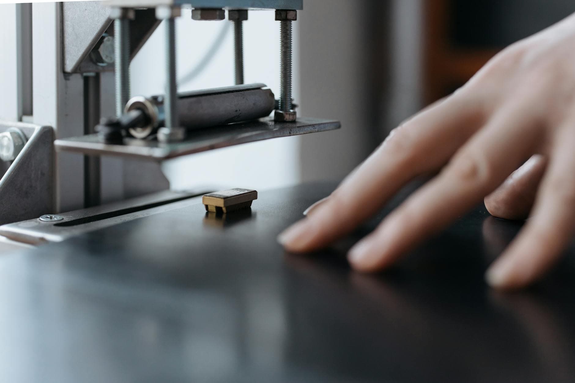 Person using a bank card for contactless payment at a modern checkout counter.