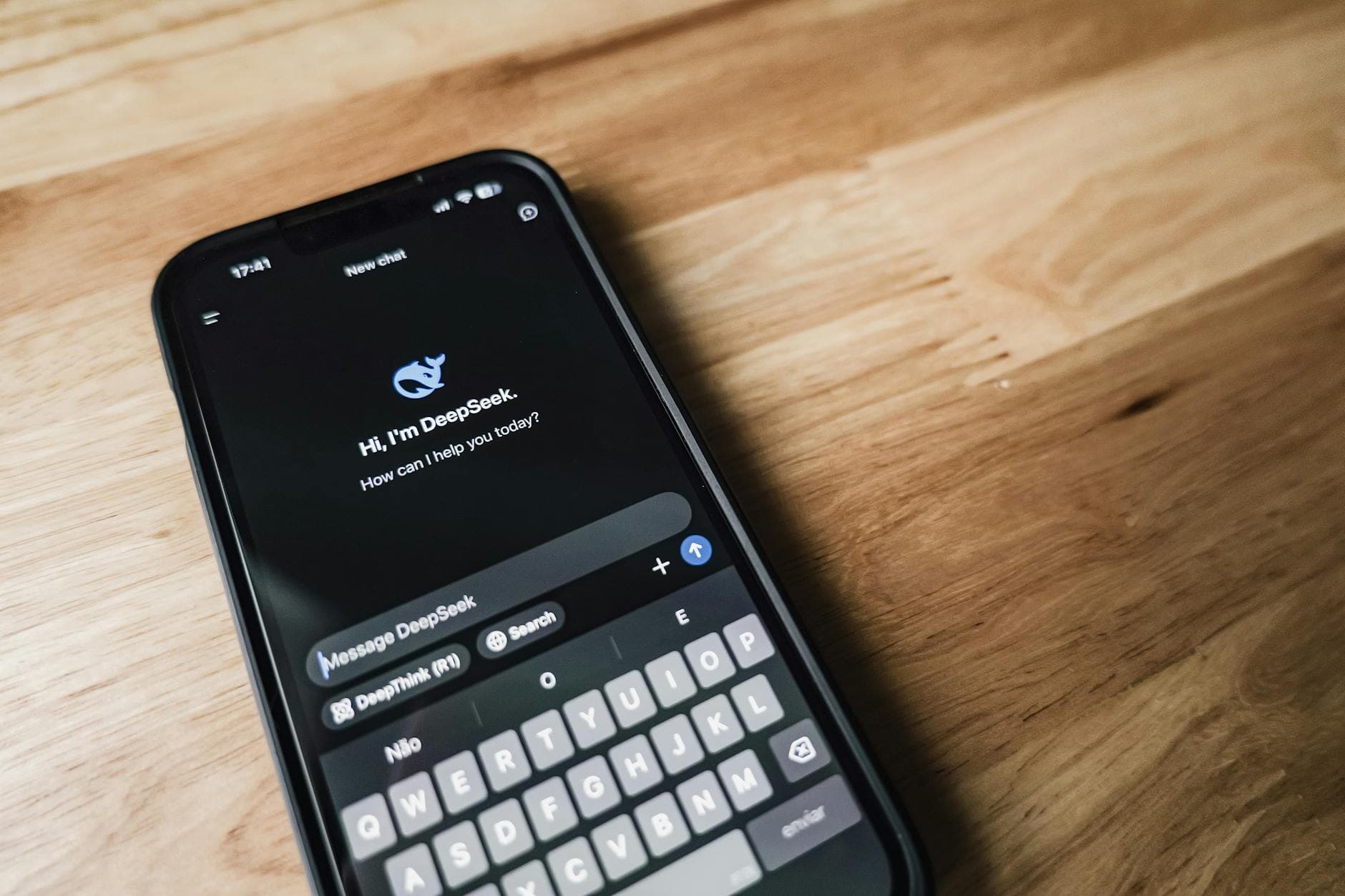 Hand holding a smartphone with AI chatbot app, emphasizing artificial intelligence and technology.